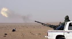 Un rebelde disparando desde una camioneta con armas antiareas en el desierto libio. | EFE